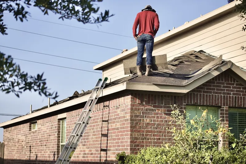 Professional roofer working on a residential roof in Morganville
